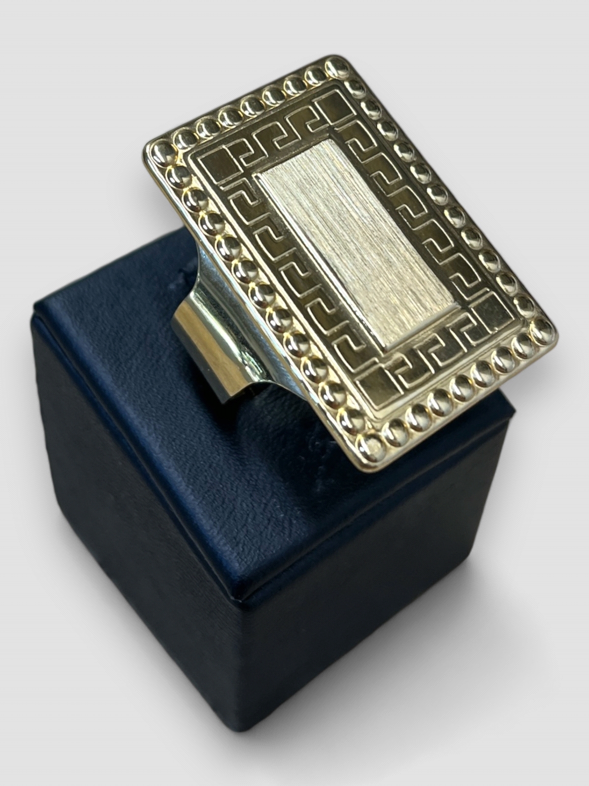 Anillo hombre Oro 18K tipo sello rectangular con diseño guarda Versace. Peso 15g 15.00grs.